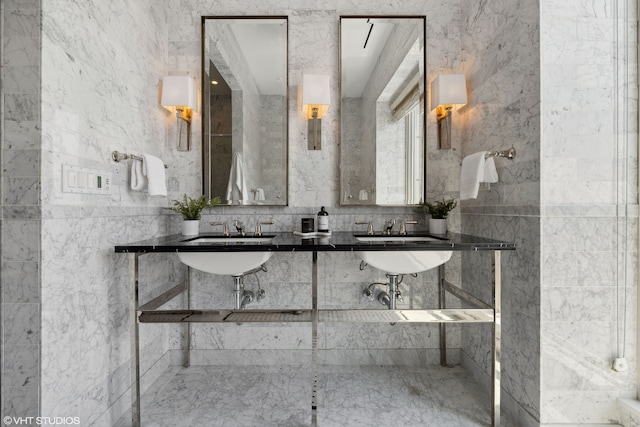 bathroom featuring tile walls and dual sinks