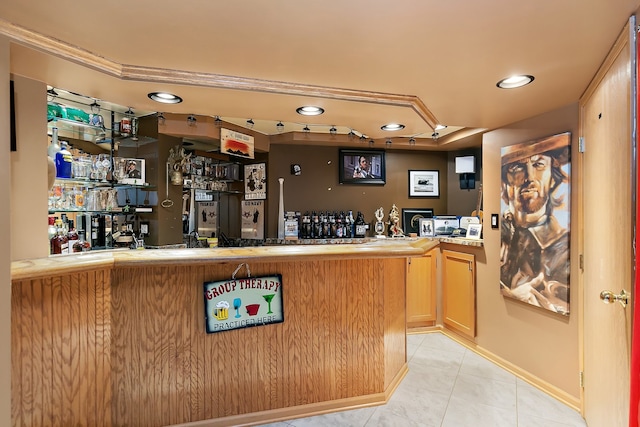 bar featuring light tile patterned floors and light brown cabinets