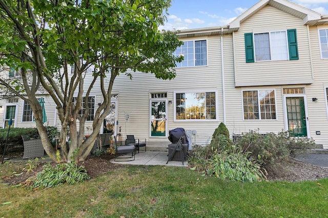 rear view of house featuring a patio area and a lawn