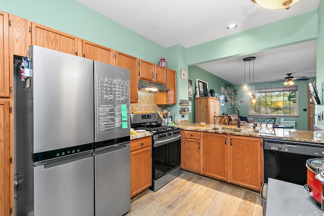 kitchen with hanging light fixtures, ceiling fan, appliances with stainless steel finishes, light hardwood / wood-style flooring, and sink