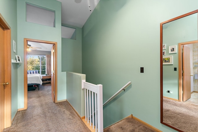 corridor featuring vaulted ceiling and light carpet