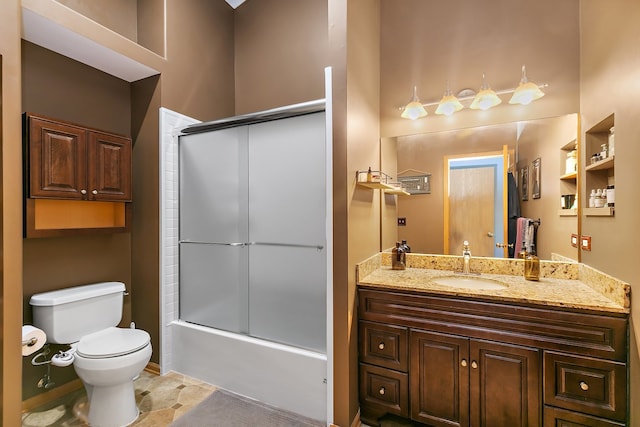 full bathroom featuring vanity, bath / shower combo with glass door, and toilet