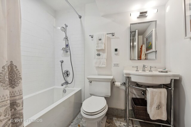 bathroom featuring shower / bath combination with curtain and toilet