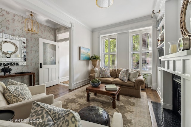 living room with dark wood-type flooring, crown molding, and a chandelier