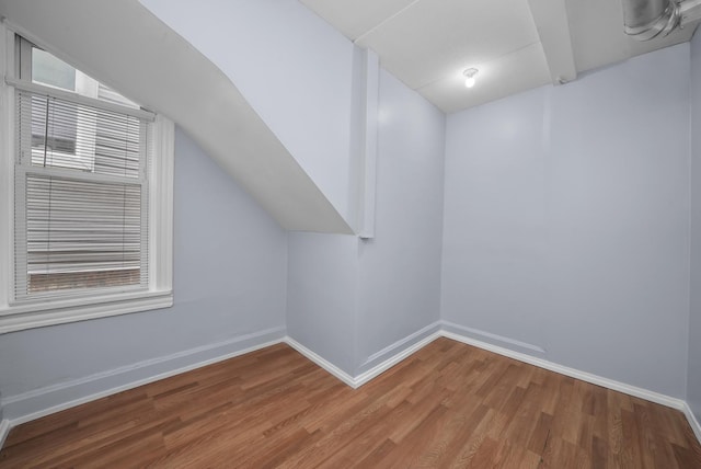 additional living space with lofted ceiling and hardwood / wood-style flooring