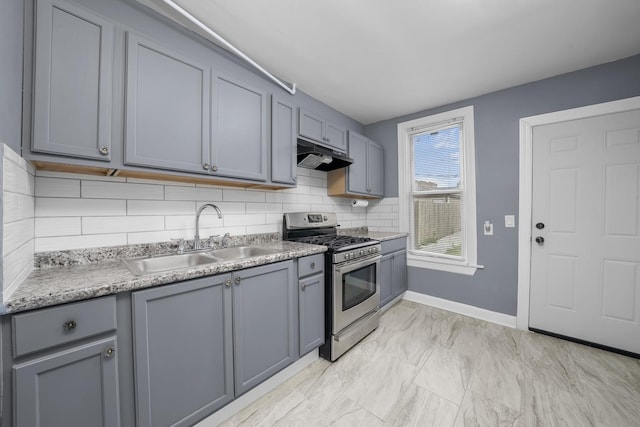 kitchen with gray cabinets, tasteful backsplash, stainless steel range with gas cooktop, and sink