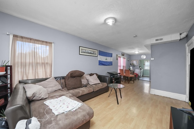 living room with light hardwood / wood-style flooring and a textured ceiling