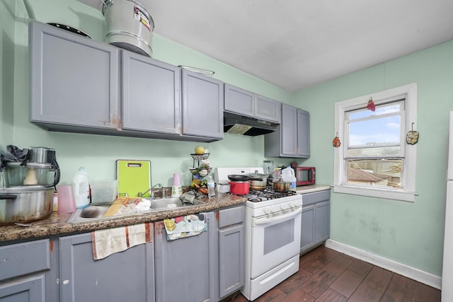 kitchen with sink, gray cabinetry, dark hardwood / wood-style floors, and gas range gas stove