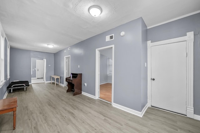 living area with a textured ceiling and light wood-type flooring