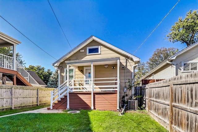 rear view of house with central air condition unit, a yard, and a deck