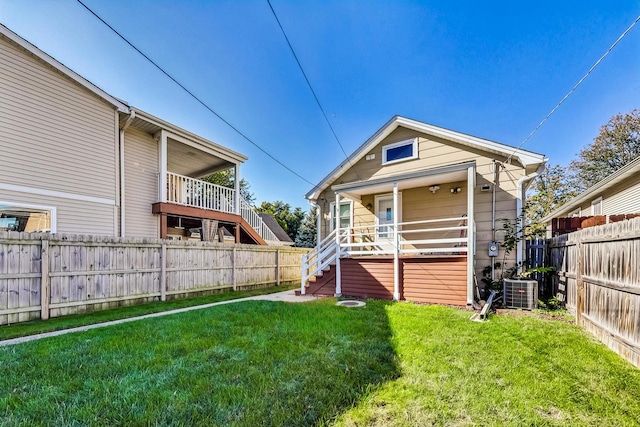 back of house with a yard and central AC