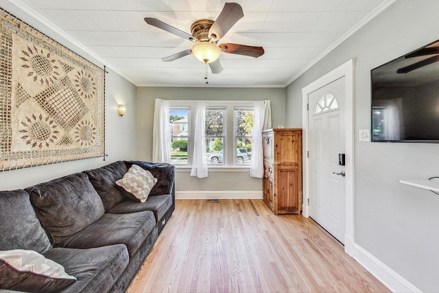 living room with crown molding, ceiling fan, and light hardwood / wood-style flooring