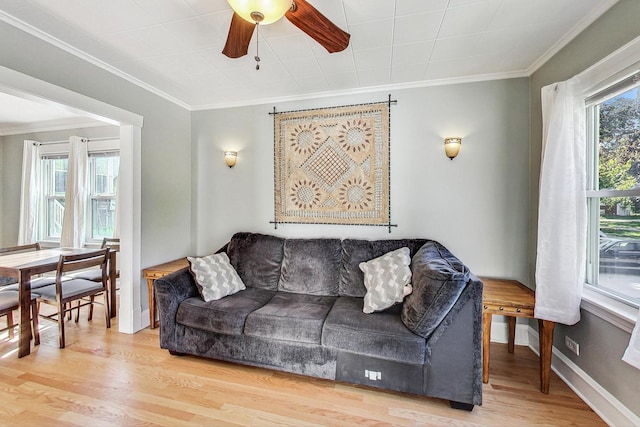 living room with hardwood / wood-style flooring, crown molding, and ceiling fan