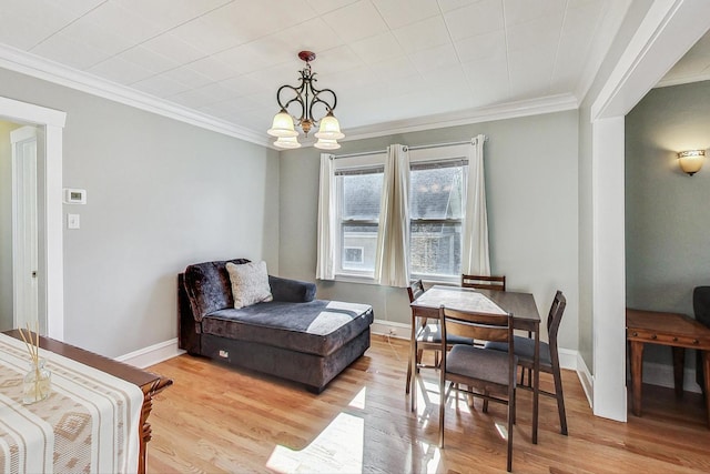 interior space featuring an inviting chandelier, ornamental molding, and light hardwood / wood-style flooring