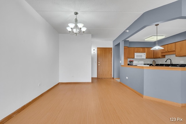 kitchen featuring range, light wood-type flooring, decorative light fixtures, and a notable chandelier