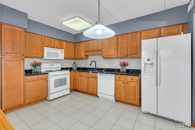 kitchen featuring tasteful backsplash, white appliances, sink, light tile patterned floors, and hanging light fixtures