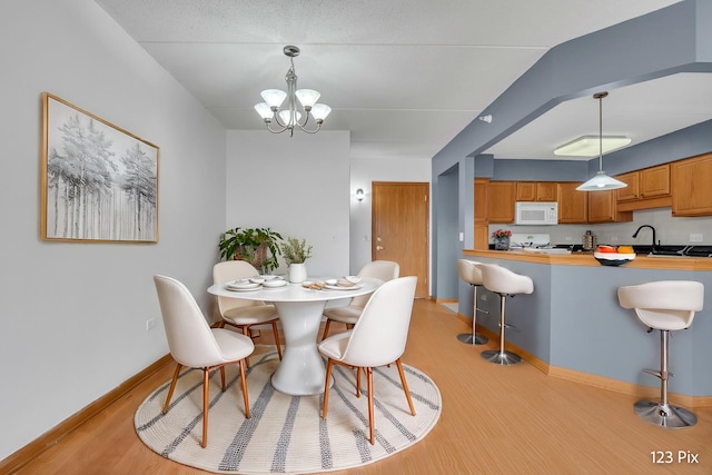 dining space featuring light hardwood / wood-style flooring and a notable chandelier