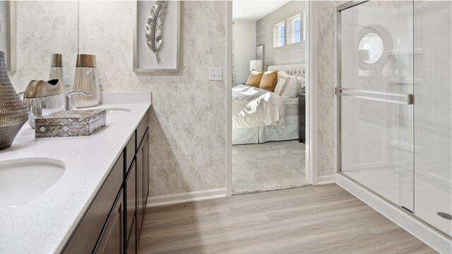 bathroom featuring a shower with door, vanity, and wood-type flooring