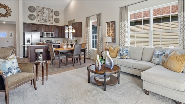 living room with light hardwood / wood-style flooring and a towering ceiling