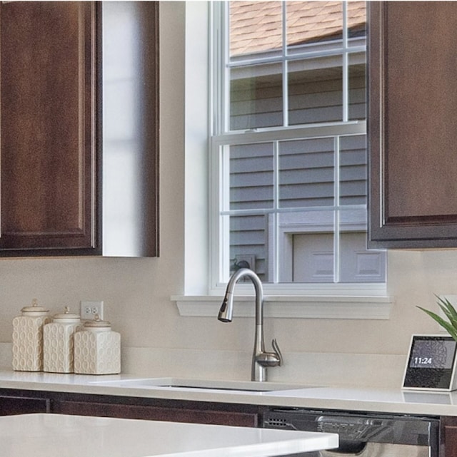 kitchen with dishwasher, sink, and dark brown cabinets