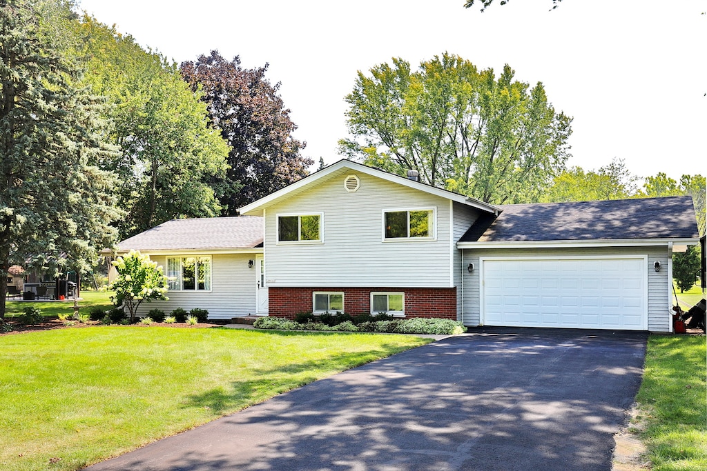 tri-level home with a front lawn and a garage