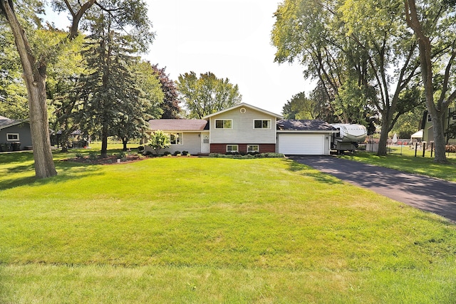 split level home with a front yard, a garage, and an outbuilding