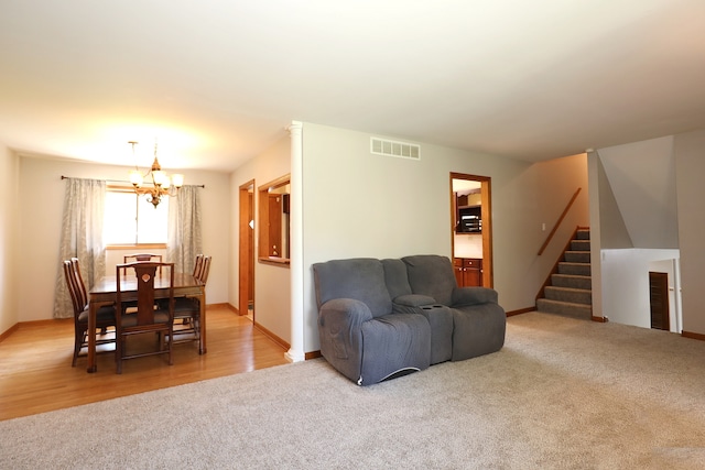 living room with a notable chandelier and light hardwood / wood-style floors