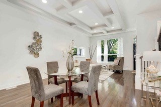 dining space featuring wood-type flooring, beamed ceiling, and coffered ceiling