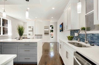 kitchen with pendant lighting, sink, tasteful backsplash, stainless steel dishwasher, and gray cabinets