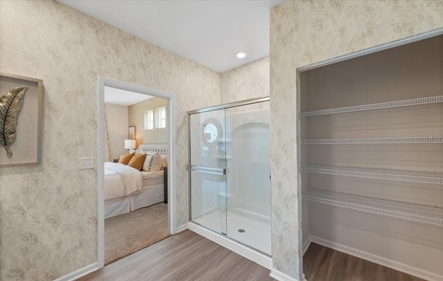 bathroom with hardwood / wood-style flooring and an enclosed shower