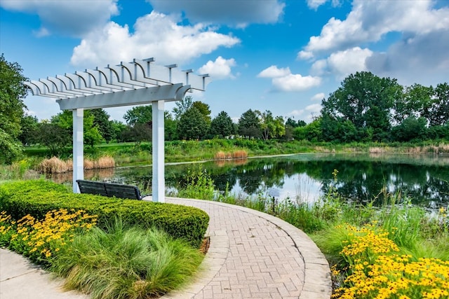 surrounding community with a water view and a pergola