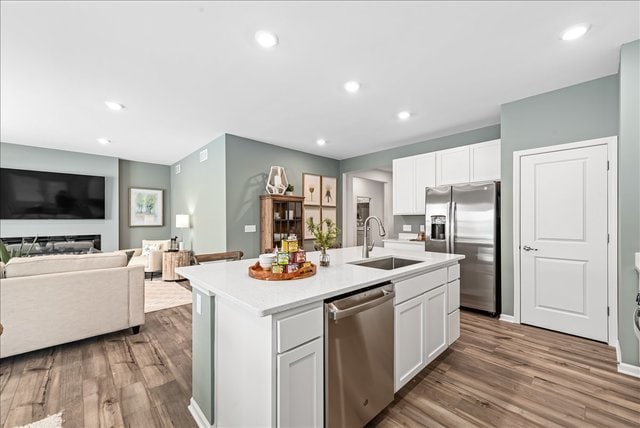 kitchen featuring appliances with stainless steel finishes, a center island with sink, sink, and white cabinets