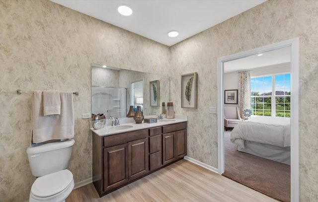 bathroom with hardwood / wood-style floors, vanity, walk in shower, and toilet