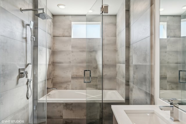 bathroom with vanity and shower with separate bathtub