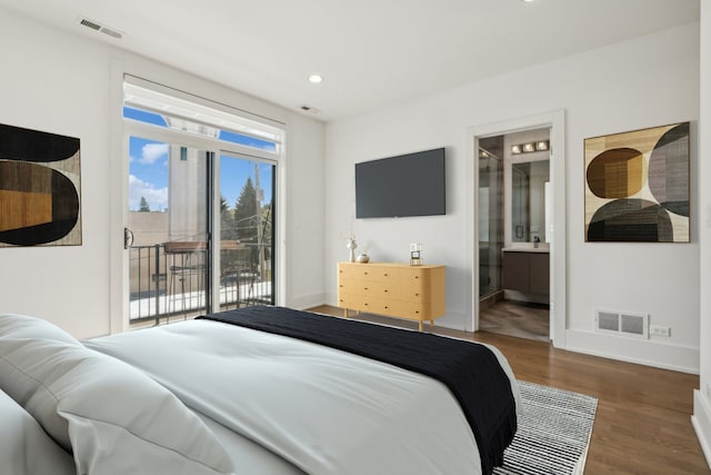 bedroom with hardwood / wood-style flooring, ensuite bath, and access to exterior