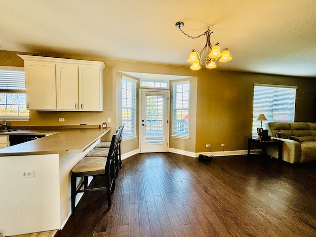 kitchen featuring a wealth of natural light, dark wood-type flooring, white cabinetry, and pendant lighting