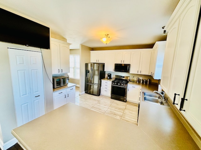 kitchen featuring sink, white cabinetry, stainless steel appliances, and light tile patterned floors