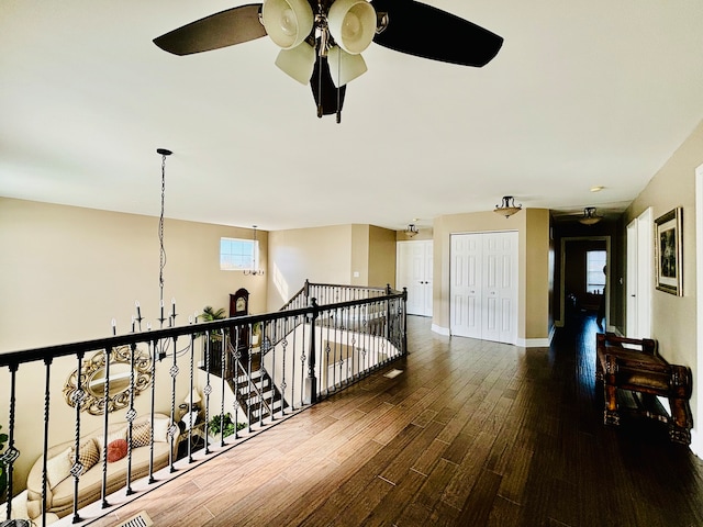 corridor featuring dark hardwood / wood-style floors and an inviting chandelier