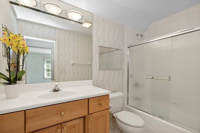 full bathroom with lofted ceiling, bath / shower combo with glass door, vanity, and toilet