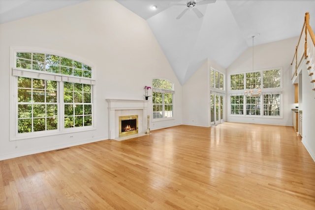 unfurnished living room featuring a premium fireplace, high vaulted ceiling, light hardwood / wood-style flooring, and ceiling fan