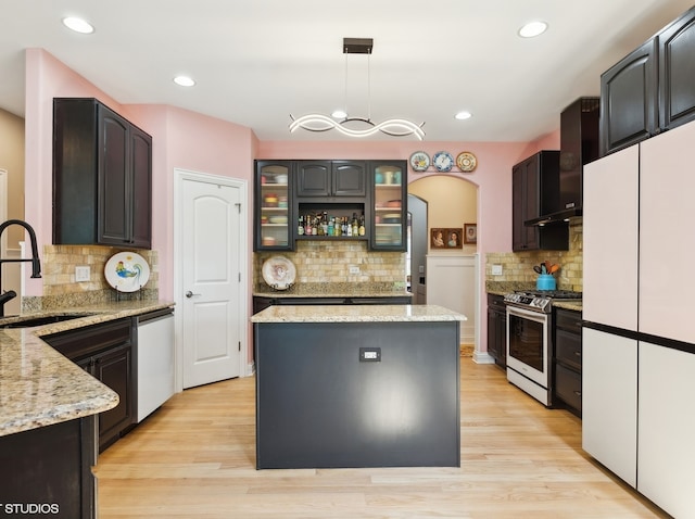 kitchen featuring light hardwood / wood-style floors, decorative light fixtures, appliances with stainless steel finishes, and sink