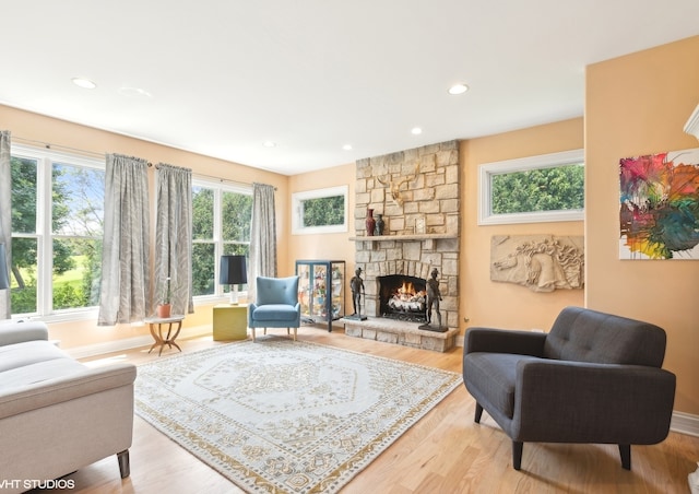 interior space featuring plenty of natural light, light wood-type flooring, and a stone fireplace