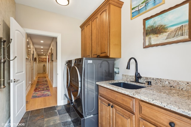 washroom with washing machine and dryer, cabinets, dark hardwood / wood-style flooring, and sink