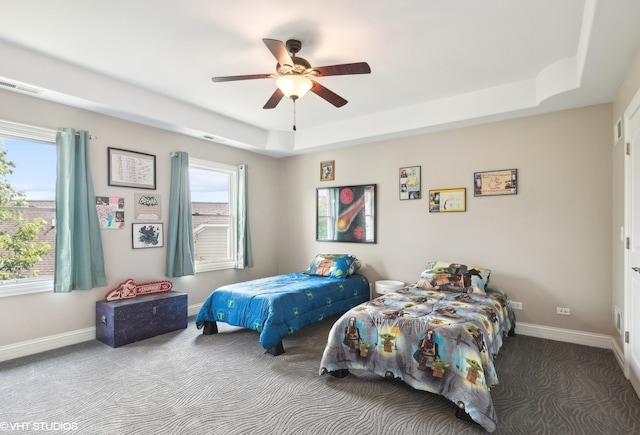 bedroom featuring ceiling fan, carpet floors, and a raised ceiling