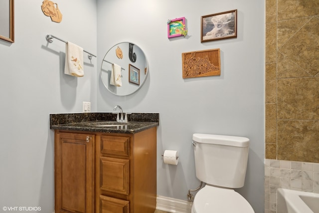 bathroom with a bath, vanity, and toilet