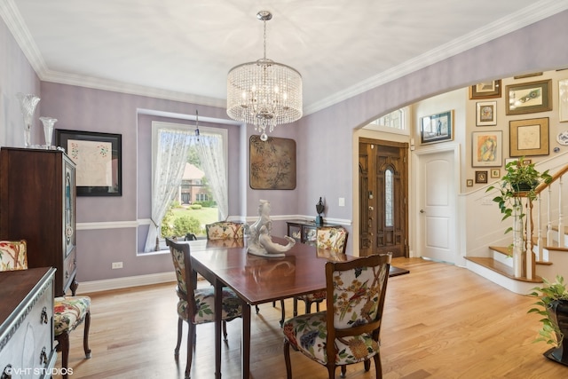 dining space featuring an inviting chandelier, light hardwood / wood-style flooring, and crown molding