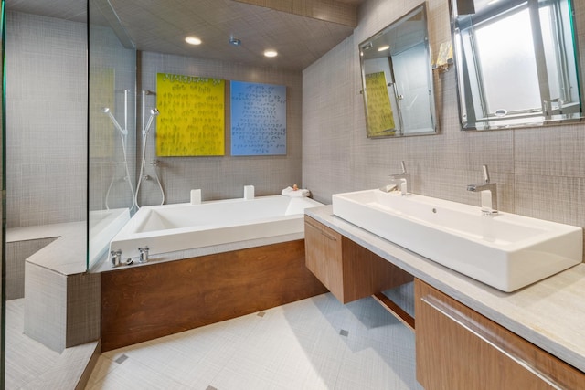 bathroom featuring vanity, tile walls, and plus walk in shower