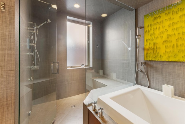 bathroom with tile walls, sink, and independent shower and bath