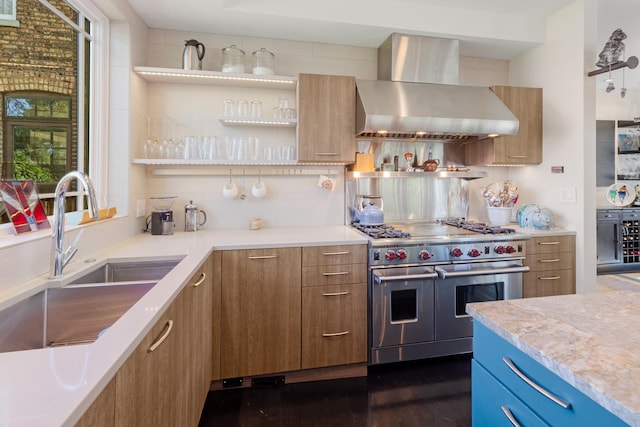 kitchen featuring sink, backsplash, dark hardwood / wood-style flooring, double oven range, and wall chimney range hood