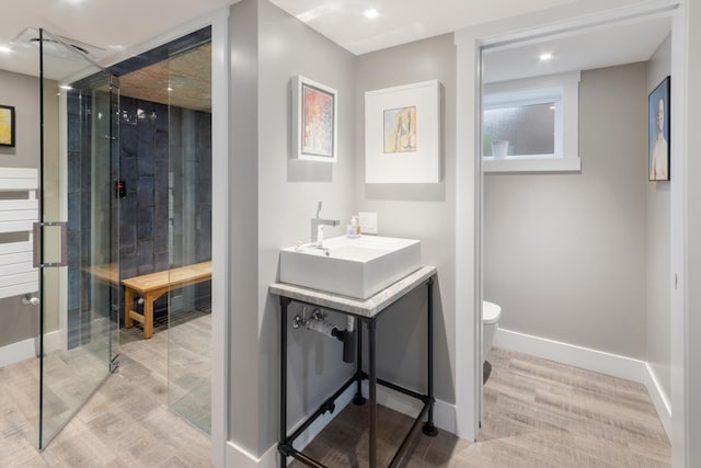 bathroom with walk in shower, wood-type flooring, vanity, and toilet